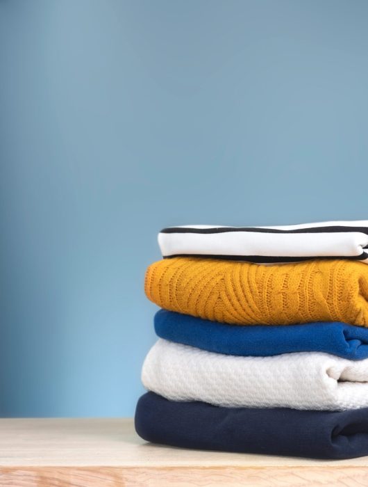 Stack,Of,Colorful,Knitted,Folded,Clothes,On,Wooden,Table,Empty